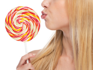 Closeup on young woman kissing lollipop