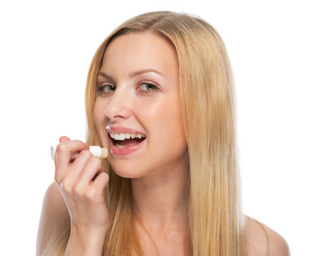 Young woman using hygienic lipstick