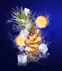 Poster Gesneden ananas in waterspatten met ijsblokjes © Soloviova Liudmyla