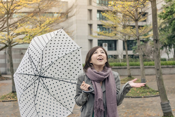 Happy smiling Asian woman holding an umbrella