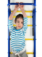 A child stands next to the a horizontal bar