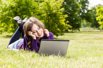 Young woman using laptop in the park