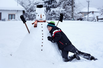 Fototapeta na wymiar Teenager building a snowman