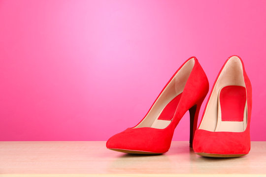 Beautiful red female shoes, on pink background