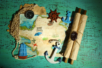 Treasure map with sea accessories, on wooden background