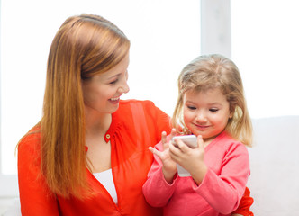 happy mother and daughter with smartphone at home