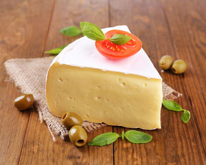 Tasty Camembert cheese with tomato, basil and olives,