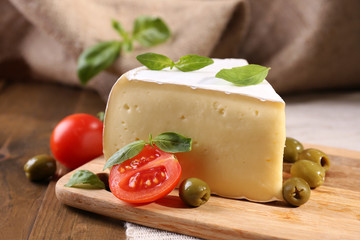 Tasty Camembert cheese with tomatoes, olives and basil,