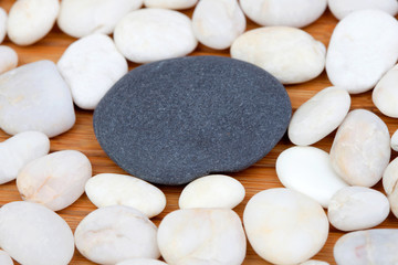 Fototapeta na wymiar A black stone and many small white stones