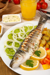Delicious grilled fish on plate on table close-up