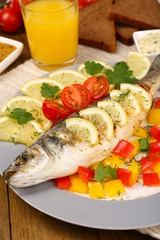 Delicious grilled fish on plate on table close-up