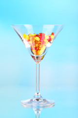 Goblet with pills on blue background