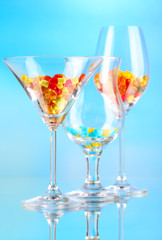 Goblets with pills on blue background