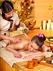 Woman getting massage in bamboo spa.