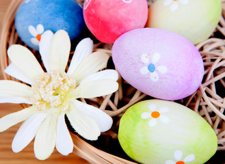 Fototapeta na wymiar Easter eggs decorated with daisies tucked in a basket
