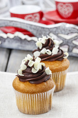 Fancy chocolate cupcakes on wooden table. Cup of coffee