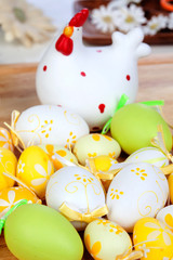 Fototapeta na wymiar Yellow and green easter eggs with a ceramic hen