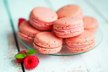 Raspberry macaroons with berries on wooden table