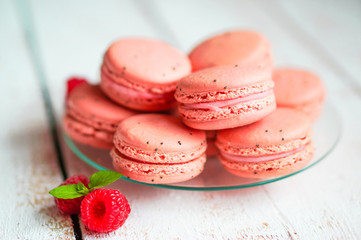 Raspberry macaroons with berries on wooden table