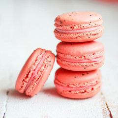 Raspberry macaroons with berries on wooden table