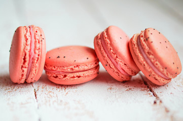 Raspberry macaroons with berries on wooden table