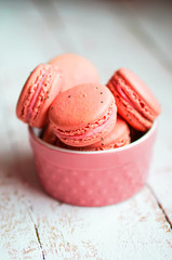 Raspberry macaroons with berries on wooden table