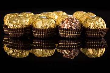 Spherical hazelnut chocolate sweets wrapped in golden foil