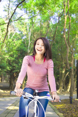 Fototapeta na wymiar Pretty girl riding a bike and enjoy free time
