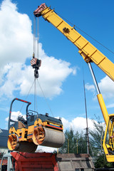 Fototapeta premium Loading compactor on the transportation machine using a crane