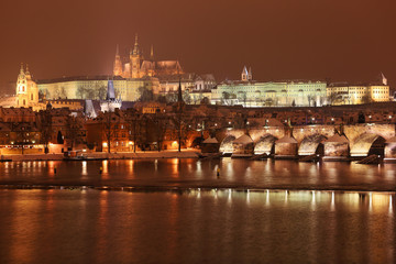 Night colorful snowy Prague gothic Castle with Charles Bridge