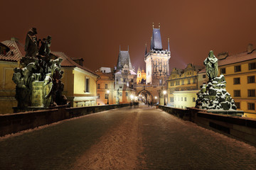 Fototapeta premium Night snowy Prague St. Nicholas' Cathedral from Charles Bridge