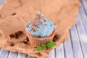 Tasty cupcake with butter cream, on color wooden  background