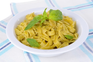 Delicious pasta with pesto on plate on table close-up
