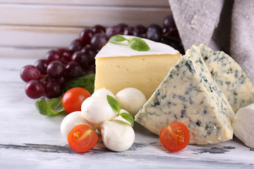 Different tasty cheese, on wooden table