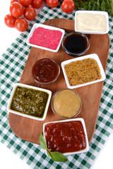 Various sauces on chopping board on table close-up