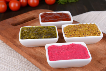 Various sauces on chopping board on table close-up