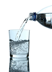 Pour water from bottle into  glass, on light blue background