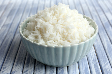 Cooked rice in bowl on wooden background