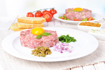 Delicious steak tartare with yolk on plate on table close-up