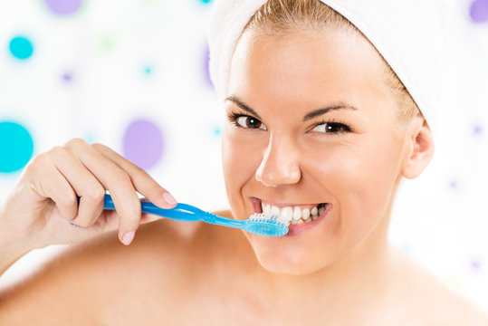 Portrait of Young woman brushing her teeth.