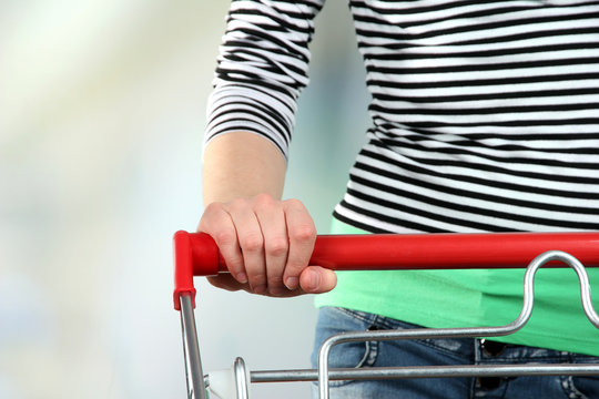 Woman with trolley in supermarket close-up