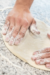 Hands working dough