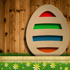 Happy Easter - colored easter egg on wooden background