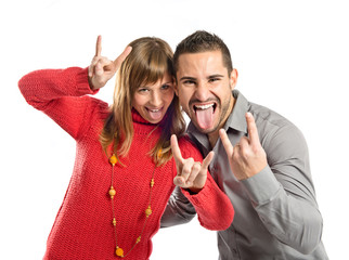 Couple doing the horn sign over white background