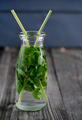 Drink of fresh mint in glass bottle on a wooden board