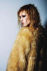 portrait of a beautiful blonde girl with wet hair in a fur coat