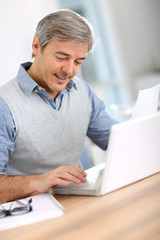 Senior businessman in office working on laptop