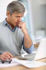 Naklejka premium Senior businessman in office working on laptop