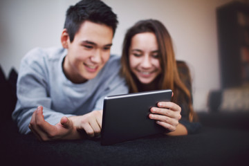 Teenage couple using digital tablet - Indoors