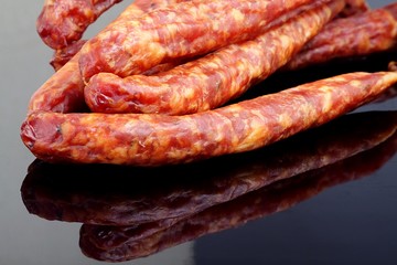 Fototapeta premium thin sausage on a black background